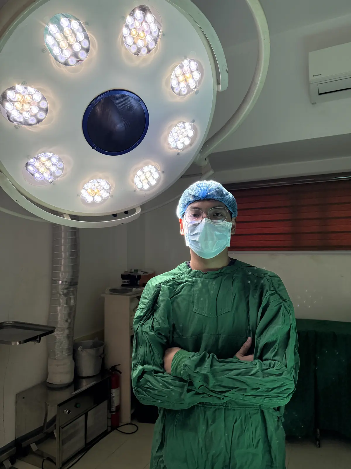Pio standing in an operating room in surgical attire